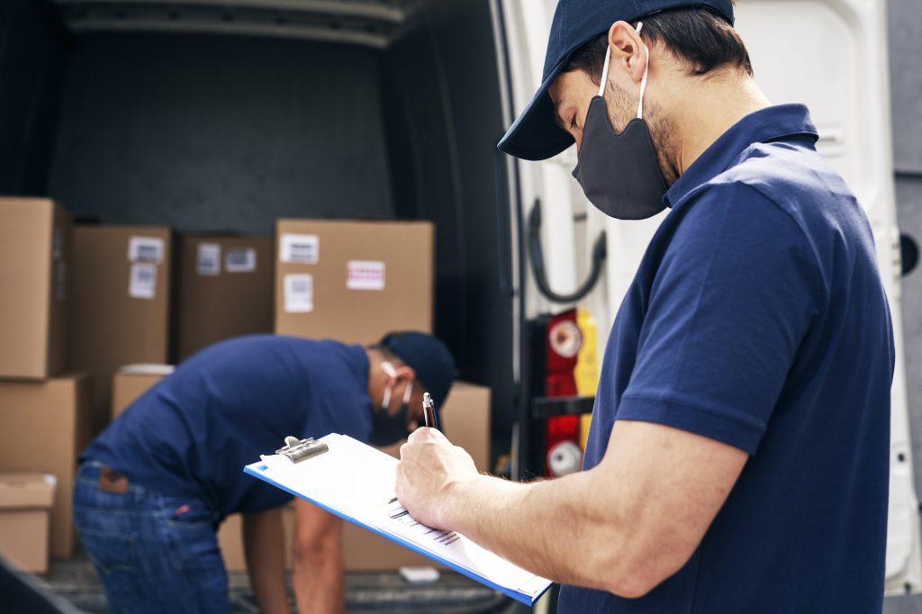 Couriers unloading packages from a delivery truck